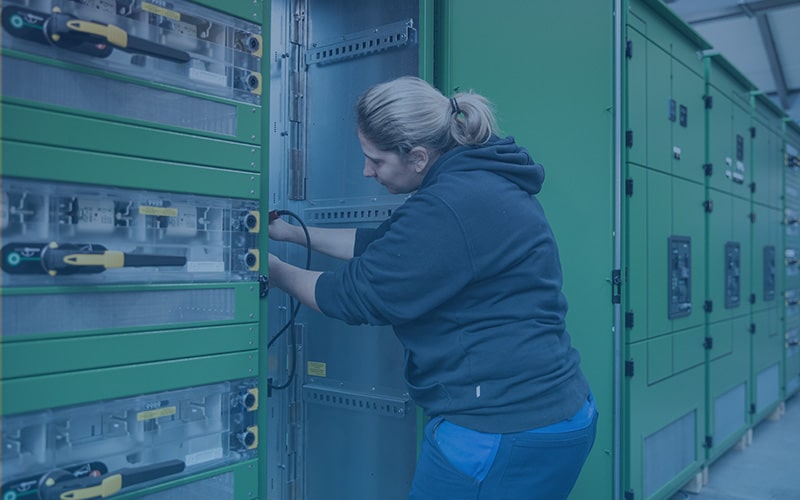 Eine Mitarbeiterin führt arbeiten an einer Schaltanlage aus